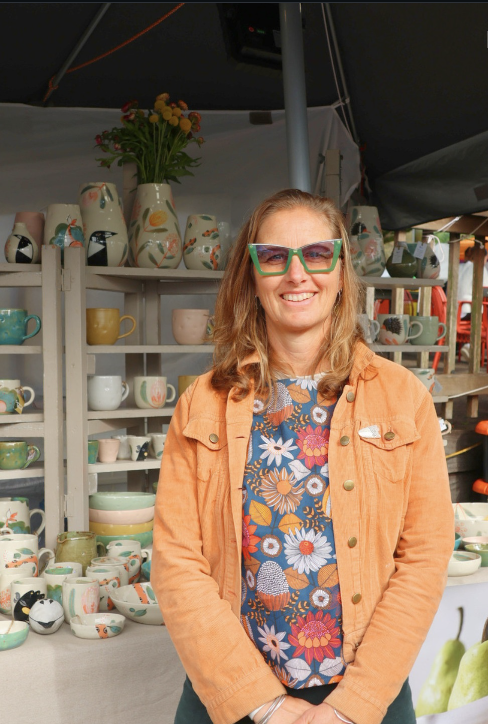 Ceramic artist standing in front of her market stall