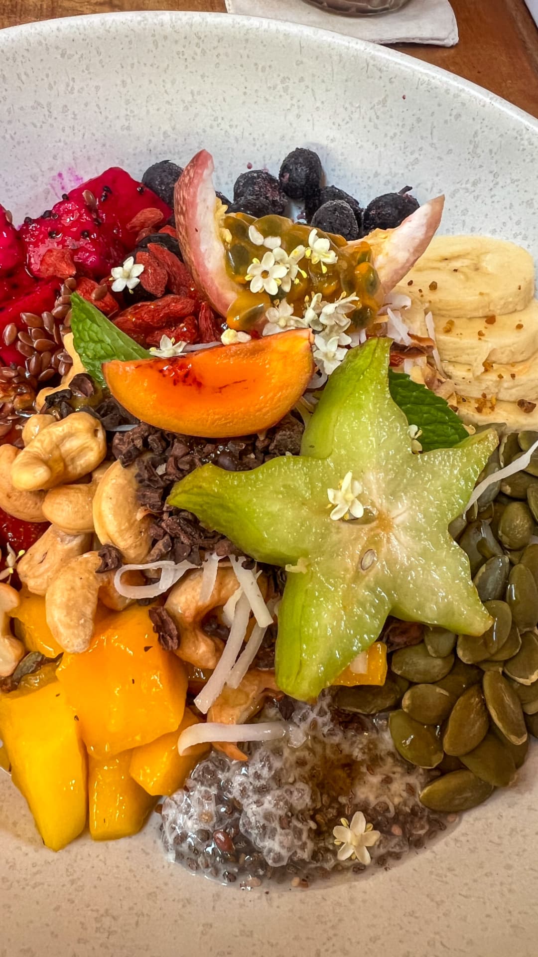 Colourful tropical fruit and seed breakfast bowl