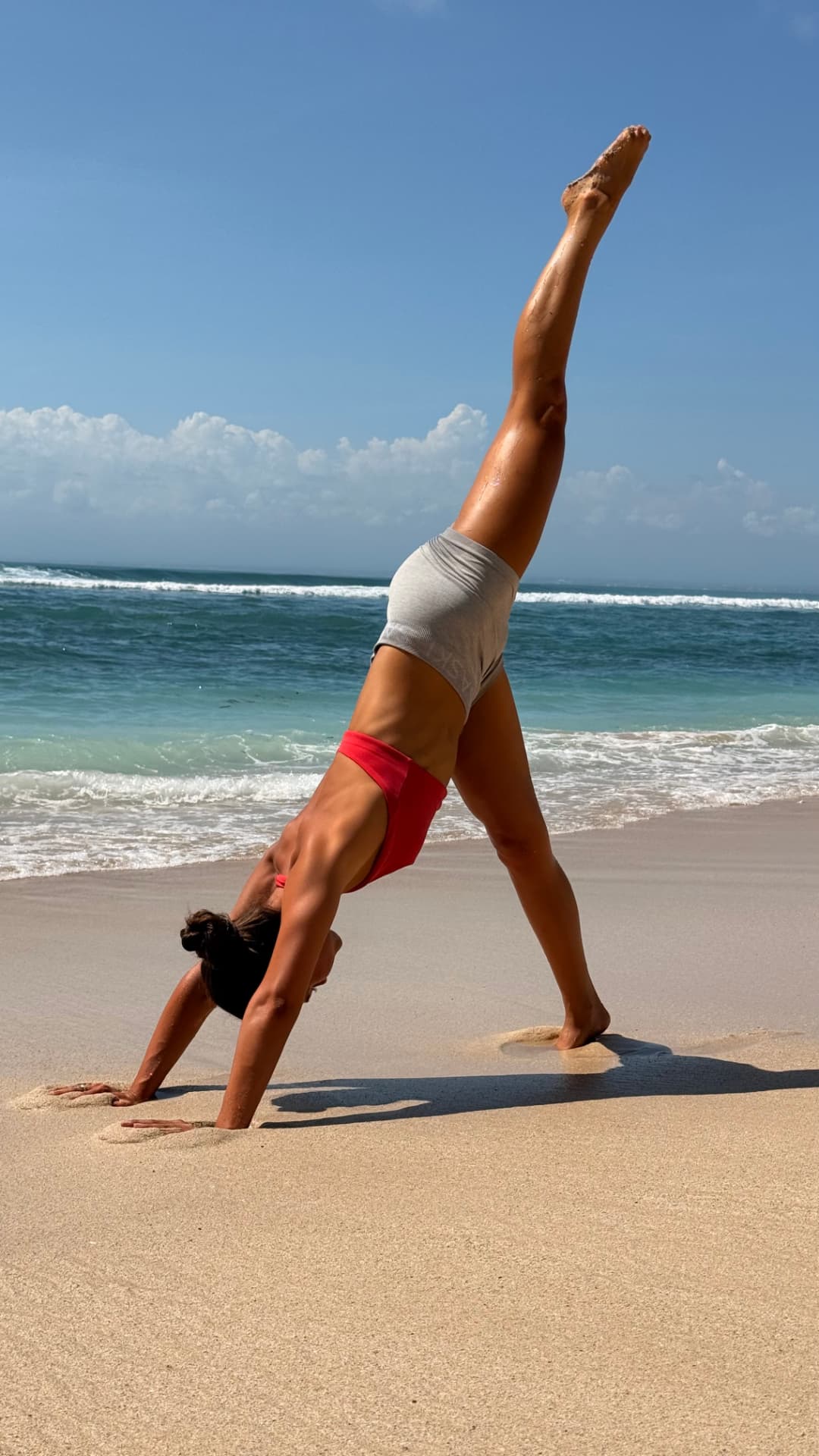 Woman doing a cartwheel on a tropical beach