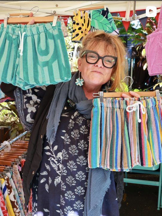 Textile maker displaying colourful handmade clothing