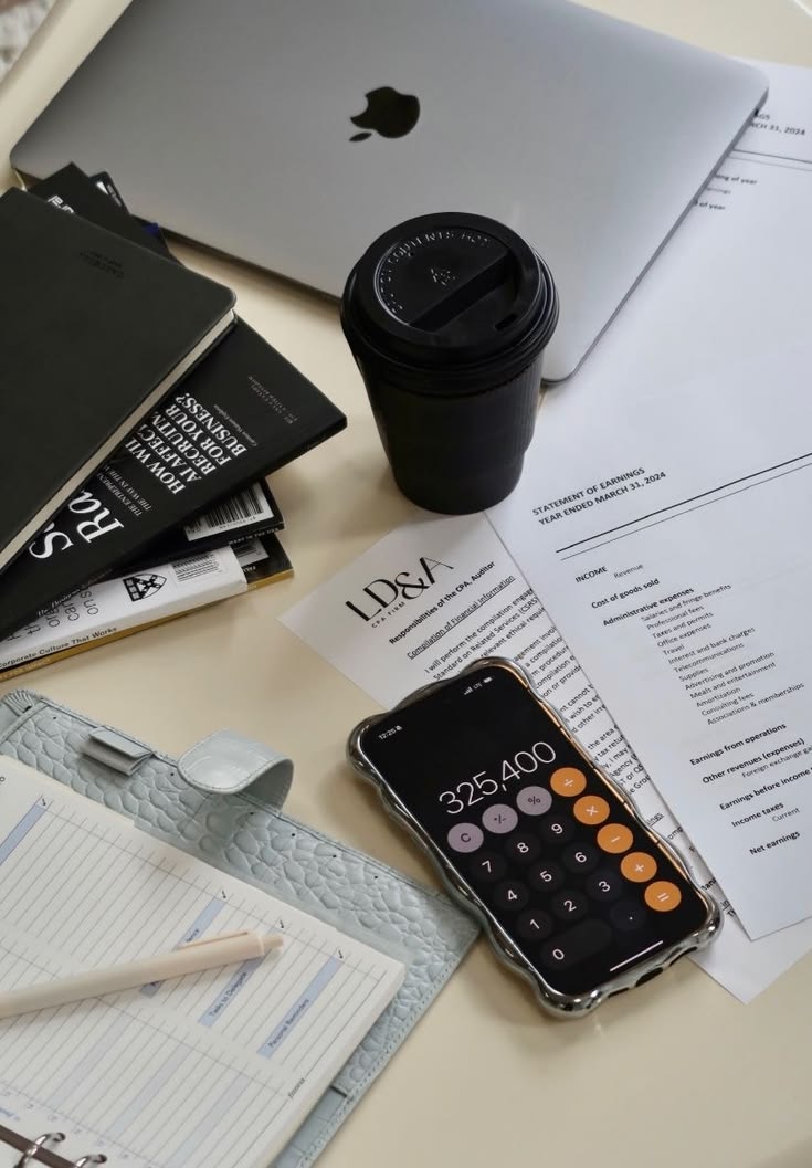 Laptop, financial statements and a calculator app on a desk